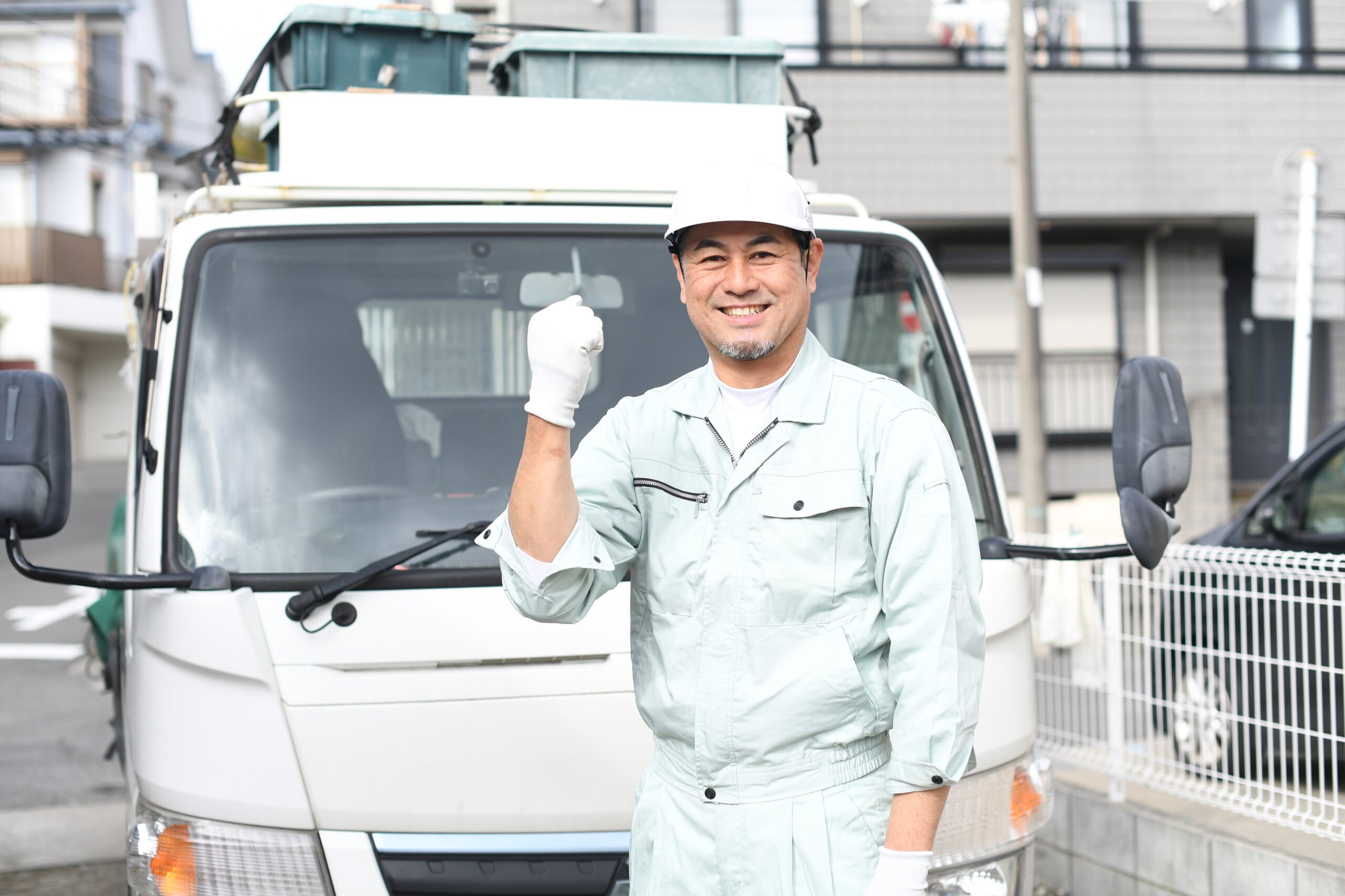 ピアノ運送の相談内容を確認する作業員と車両